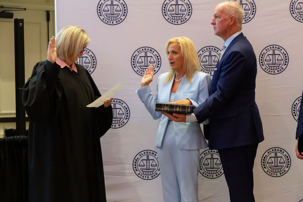 Supreme Court of Alabama Chief Justice Sarah Stewart administers the Oath of Office to 151st President of the Alabama State Bar, Jana Russell Garner, who stands alongside her husband, Paul.